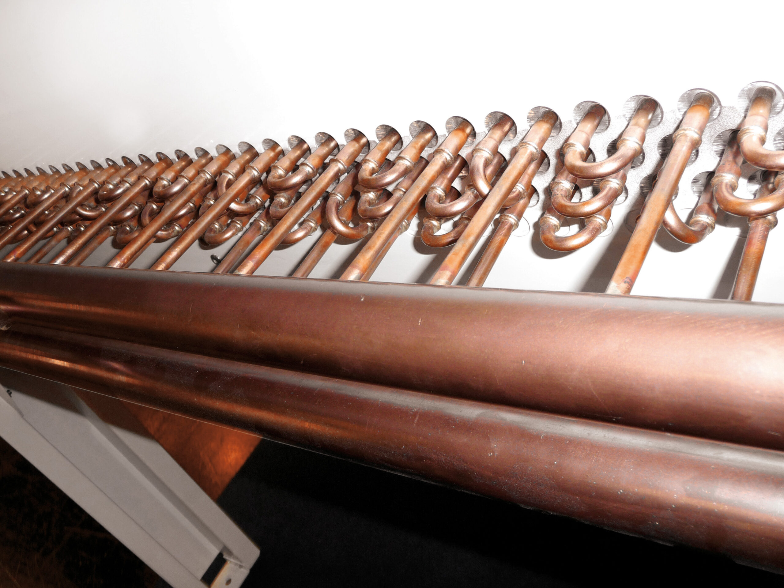 Tubes de cuivre pour chauffage ou plomberie disposés côte à côte.