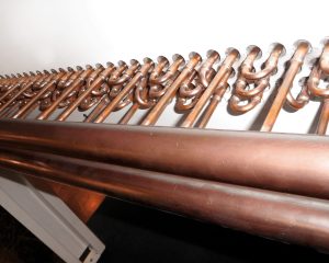 Tubes de cuivre pour chauffage ou plomberie disposés côte à côte.