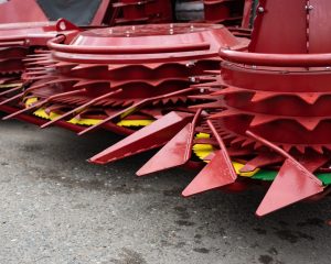 stock-photo-close-up-of-sharp-red-metal-components-of-agricultural-machinery-placed-on-a-paved-surface-2555840837